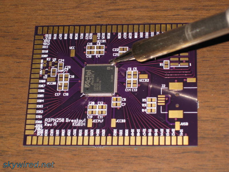 The soldering iron is used to secure two corners of the chip